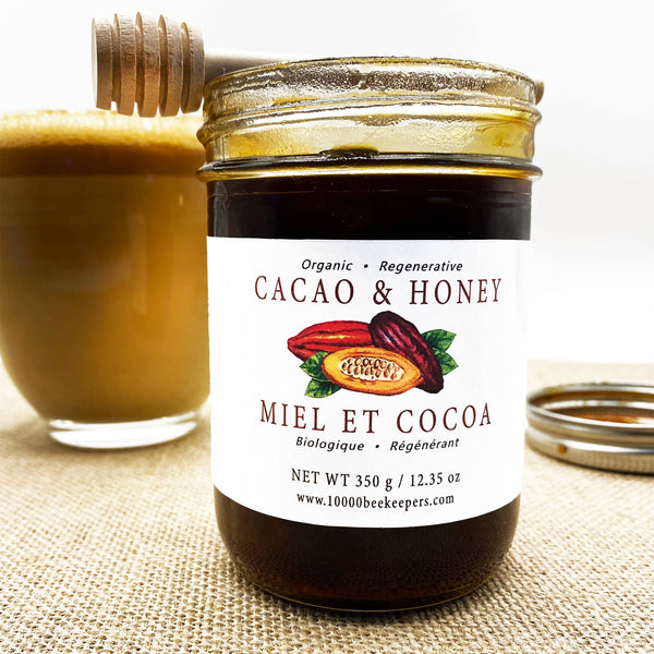 Jar of Cacao & Honey with a glass of honey on a textured surface