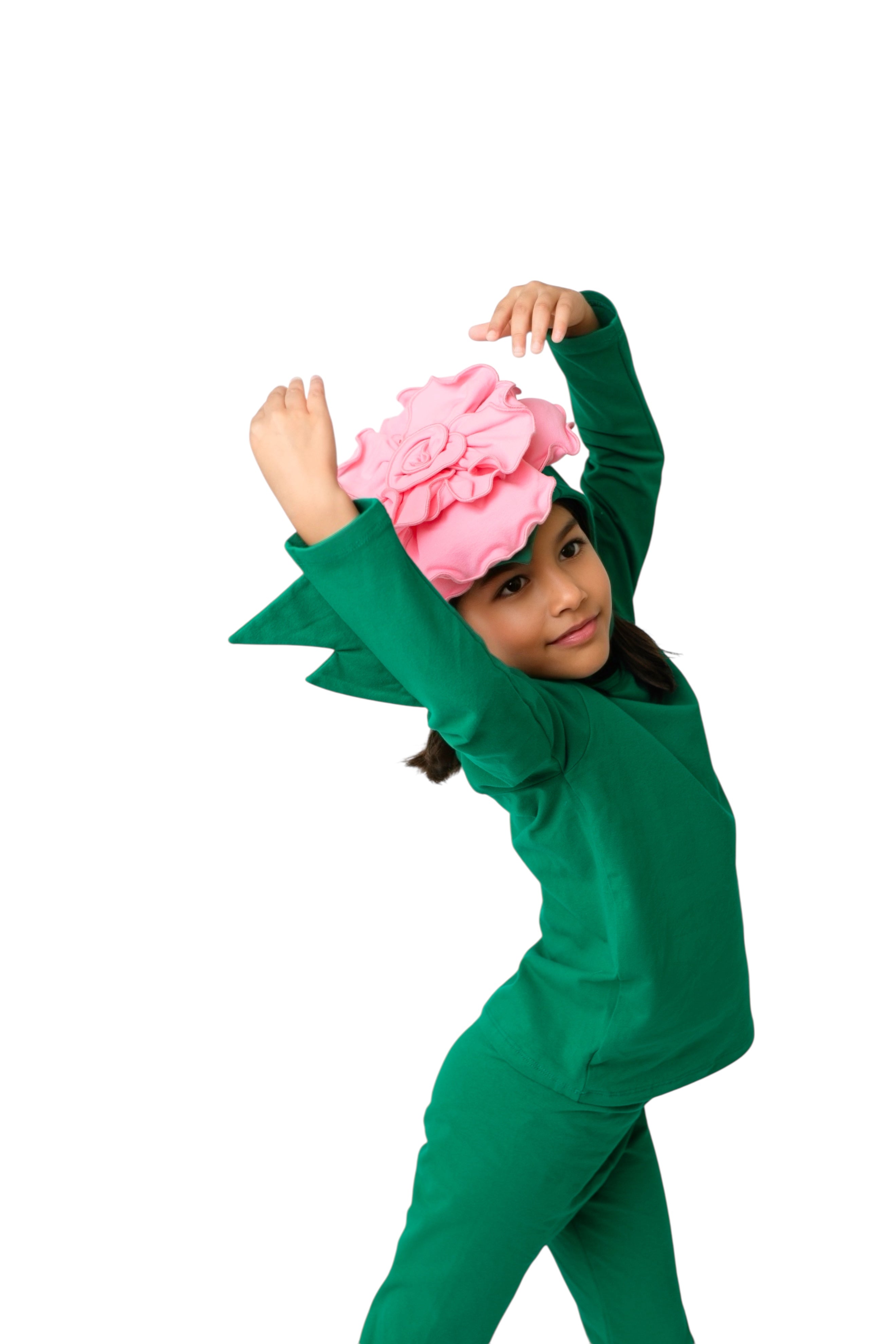 Child wearing a green outfit with a pink flower headband on a white background