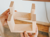 Person holding a small wooden box with a plain background
