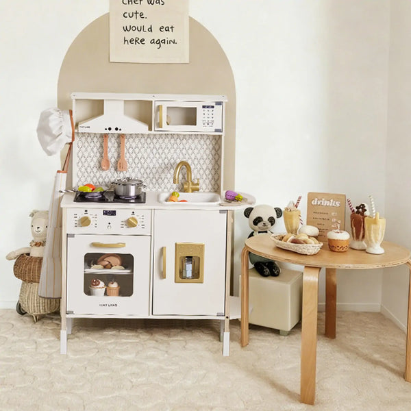 Children's play kitchen set with a dining table and chairs in a room.