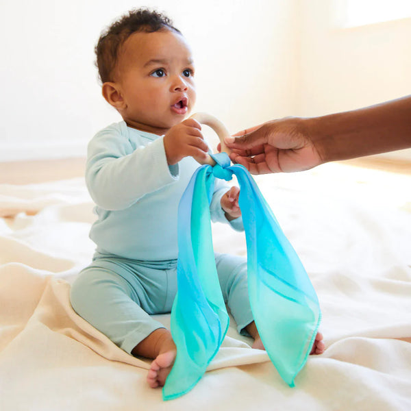 Close-up of the Sarah's Silks Sea Teether showing the natural maple wood ring and soft silk fabric detail