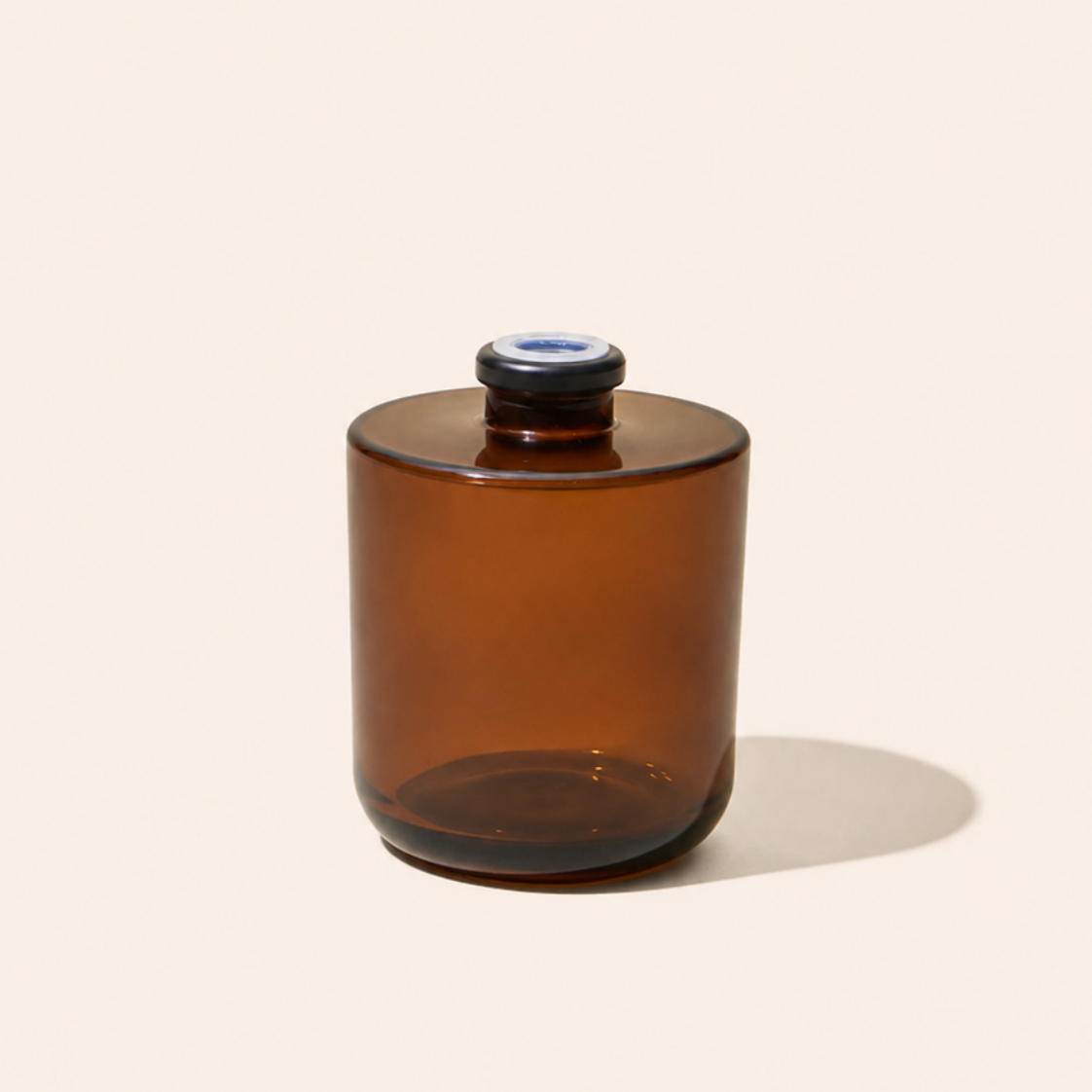 Brown glass jar with a blue cap on a beige background