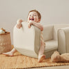 Child playing with a white chair in a cozy living room