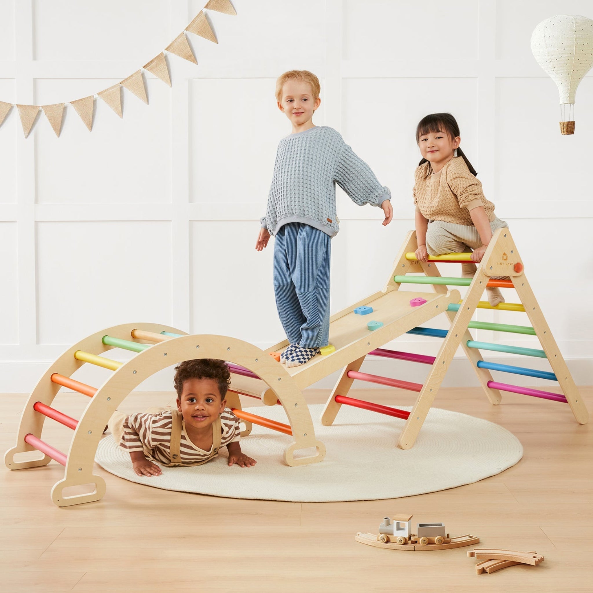 Children playing on a colorful wooden climbing toy indoors.