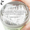 Organic decaf green mint tea sachet steeping in a white ceramic mug