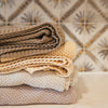 Soft pewter knitted swaddle blanket folded neatly, showing breathable open-knit construction