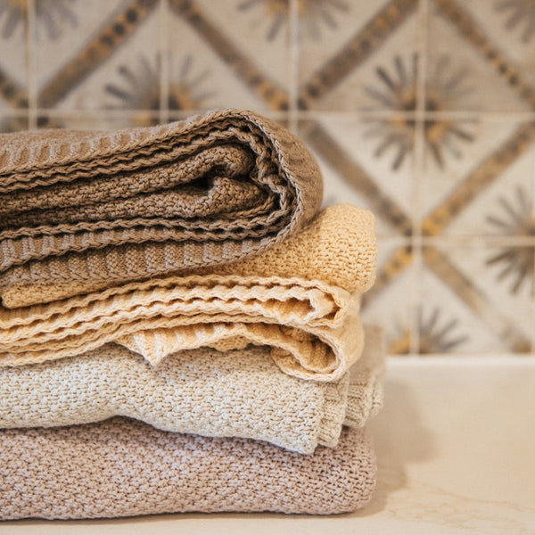 Soft pewter knitted swaddle blanket folded neatly, showing breathable open-knit construction