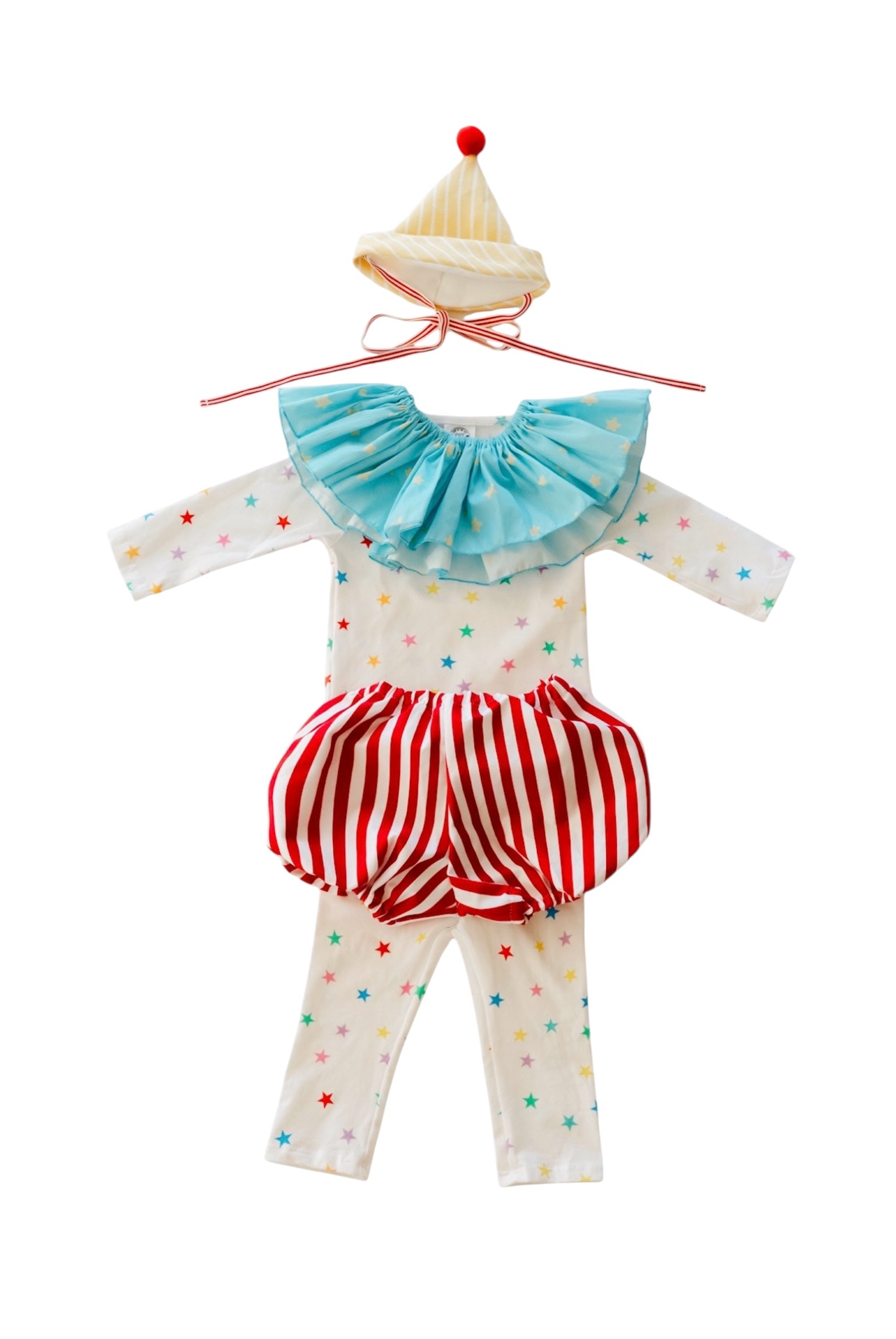 Children's outfit with a blue top, red and white striped shorts, and white pants on a hanger.