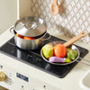 Stovetop with a pot and pan containing vegetables on a kitchen counter.