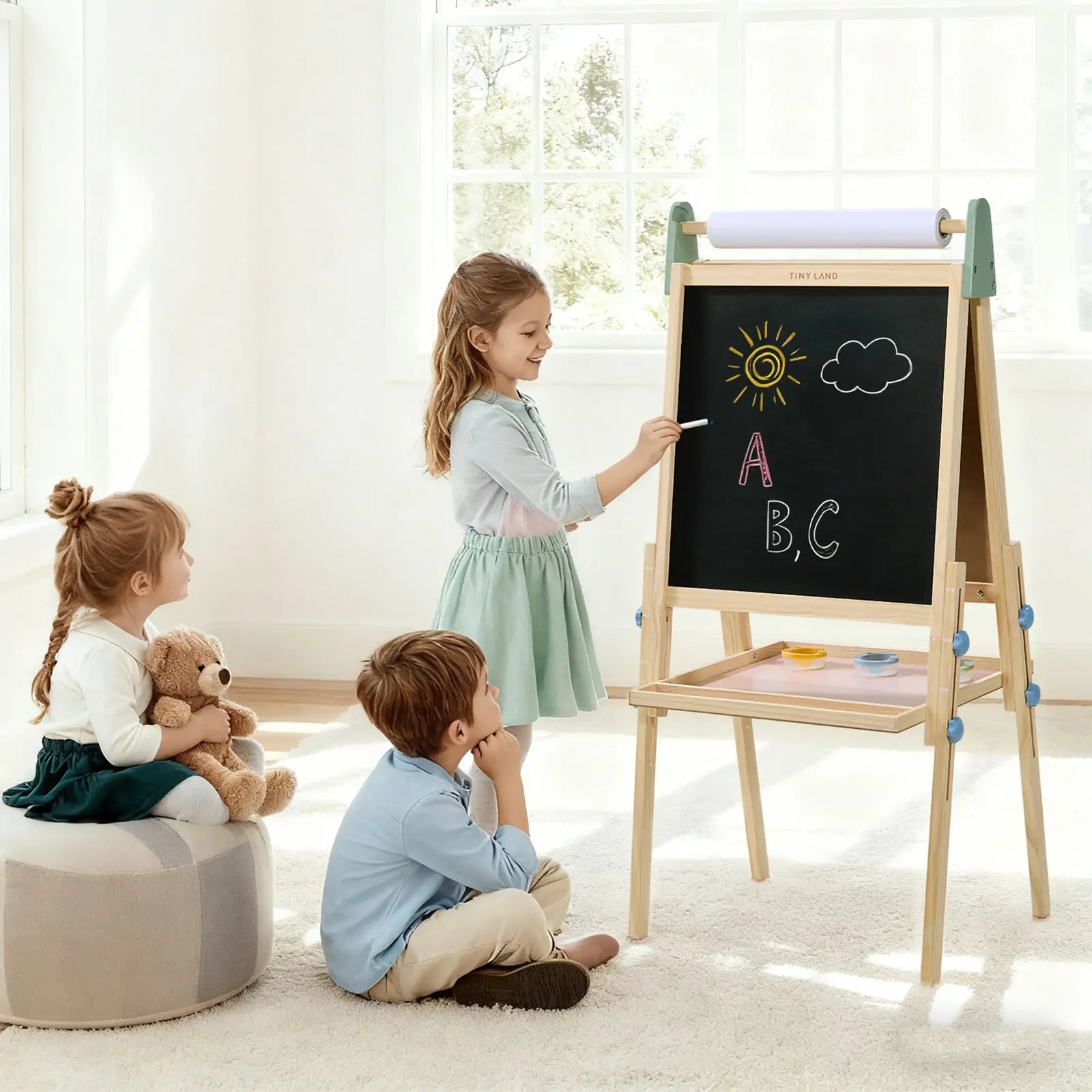 Children playing with a wooden easel in a bright room
