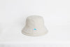 Beige bucket hat on a white background. Shop "The Cloud" Reversible Fisherman's Hat. Crafted from 7 recycled plastic bottles and 30 sq. ft. of ocean fishnet, this water-resistant hat features a unique double-brim design. The perfect sustainable gift for all-weather, ocean-conscious style.