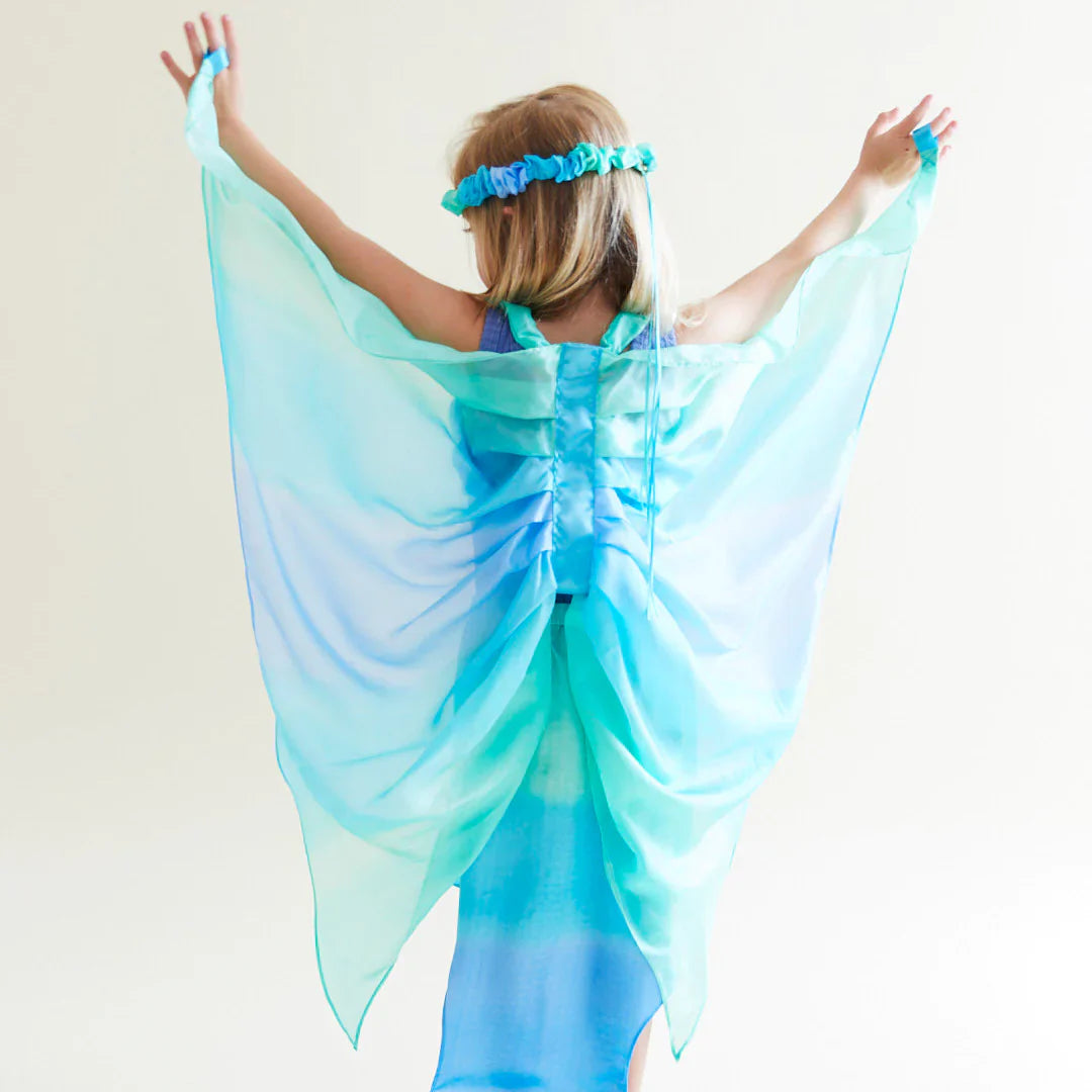Child wearing a blue fairy costume with wings against a white background