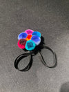 Colorful pom-pom hair tie on a gray background