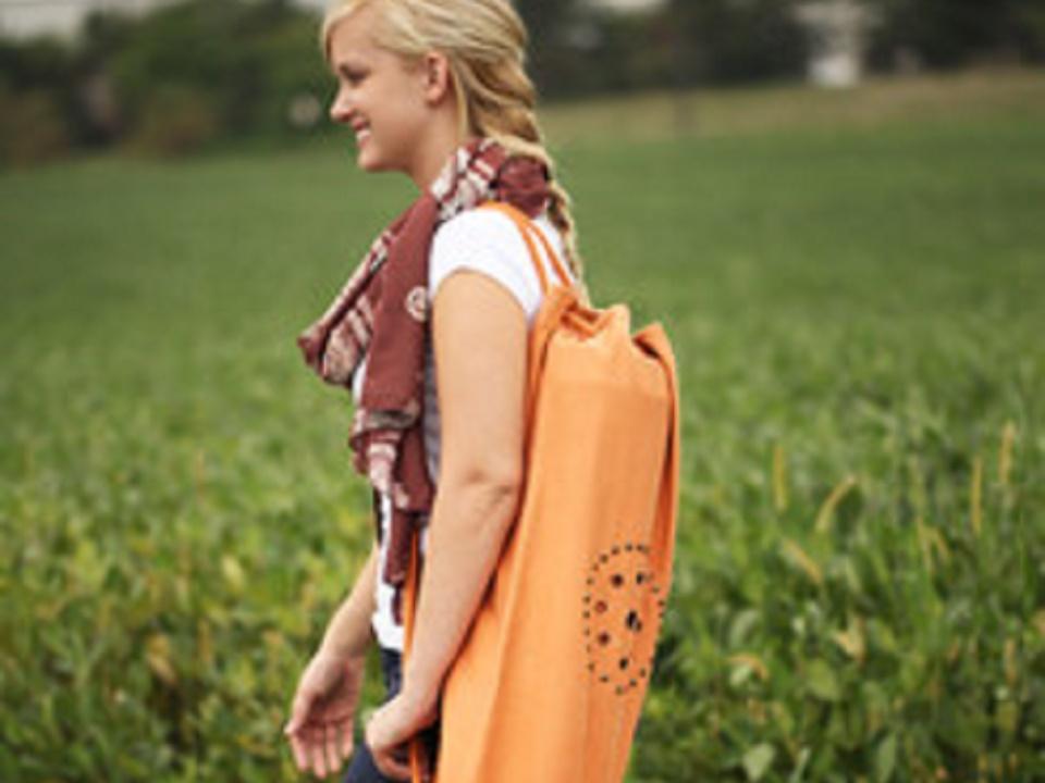 Lifestyle image of the OMSutra Chakra Rivet Yoga Mat Bag worn over the shoulder