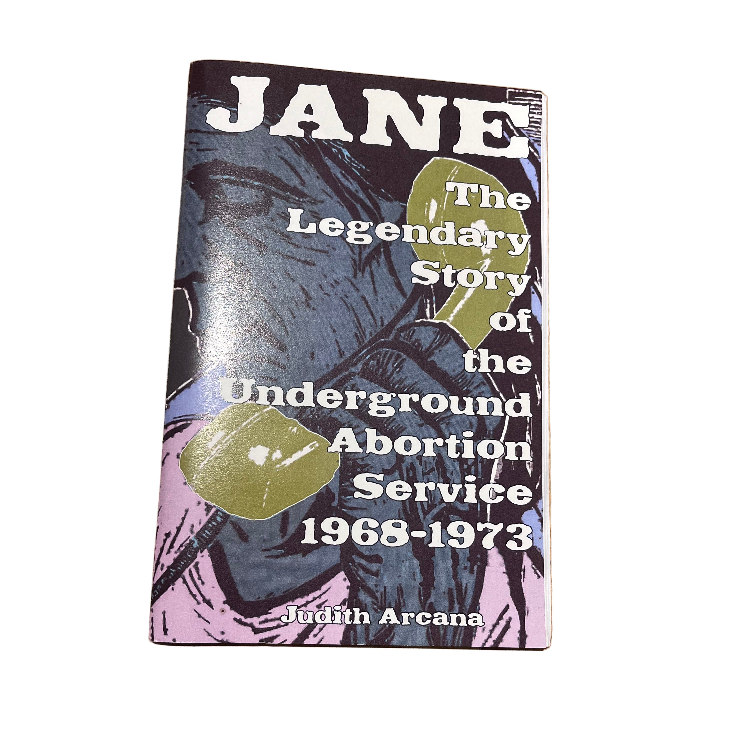 Front cover of 'Jane: The Legendary Story of the Underground Abortion Service 1968–1973' zine by Microcosm Publishing, resting on a wooden surface