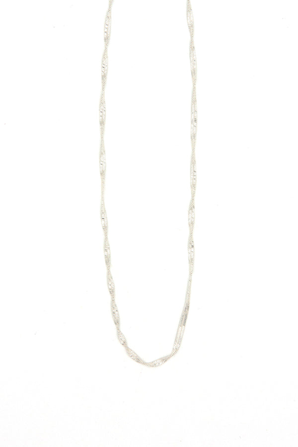 Woman wearing 19 inch twisted snake chain necklace layered with other necklaces