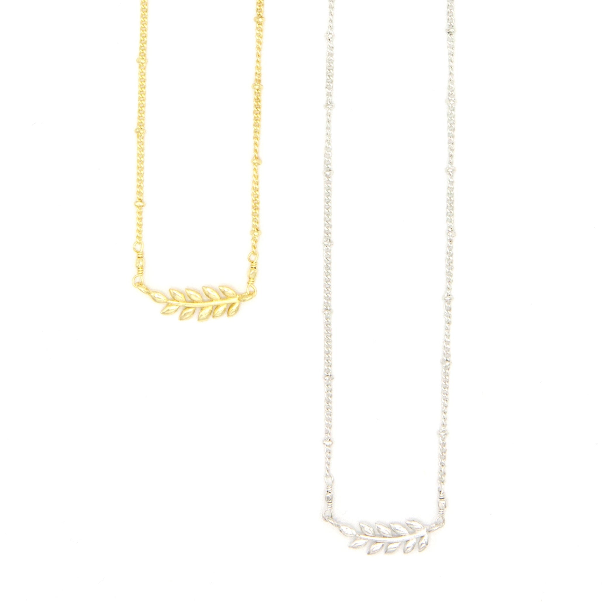 Fair trade fern necklace in gold-plated recycled brass on model