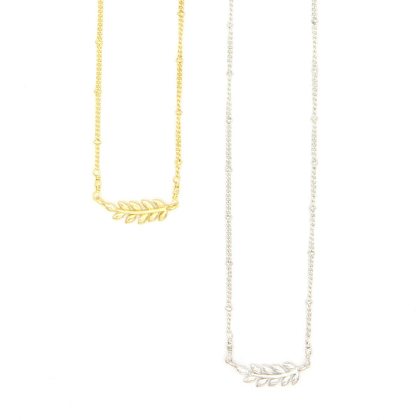 Fair trade fern necklace in gold-plated recycled brass on model
