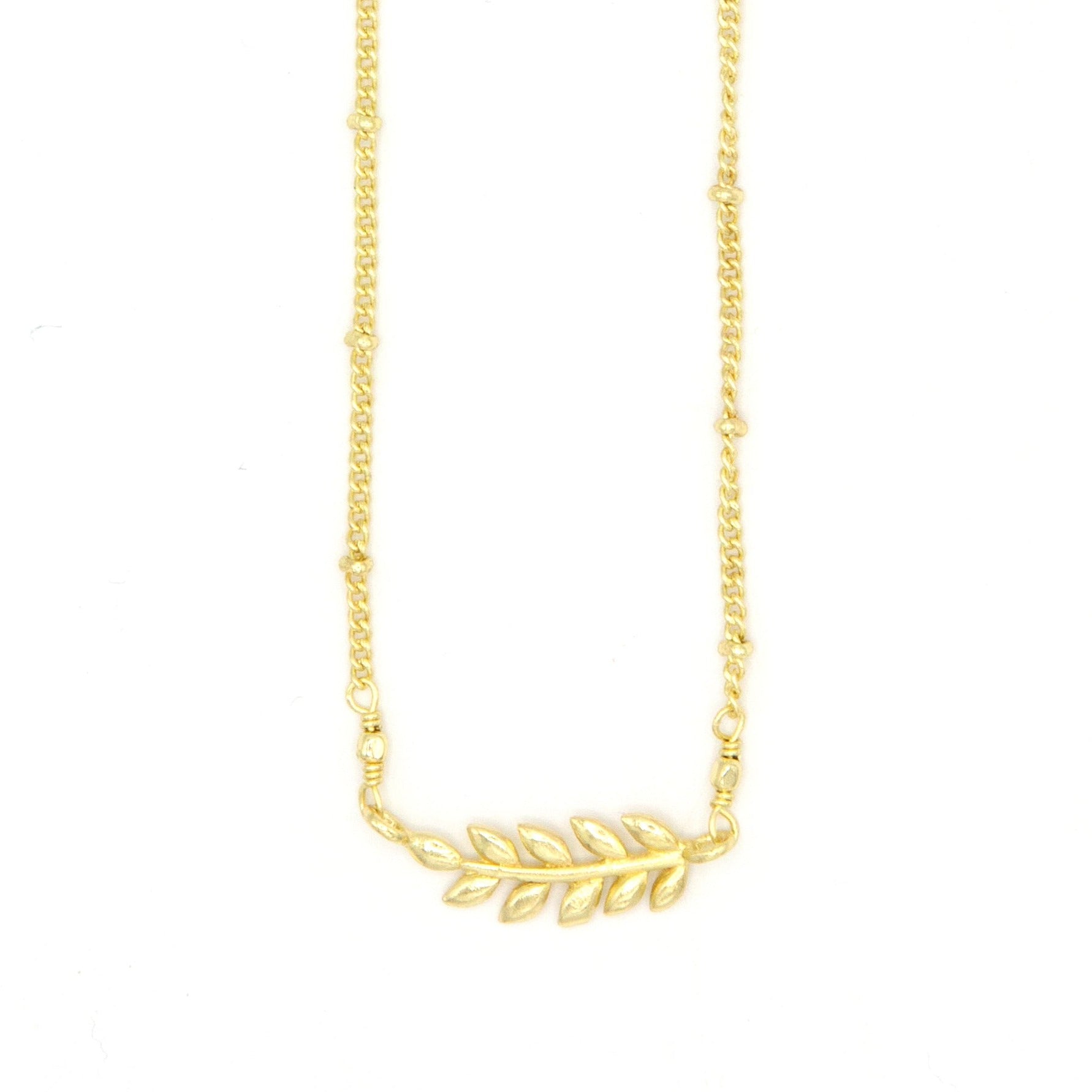 Ethically made fern necklace in recycled brass worn as a layering piece