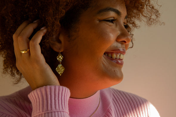 Close-up of hammered texture on recycled brass band ring by Fair Anita, shown on hand