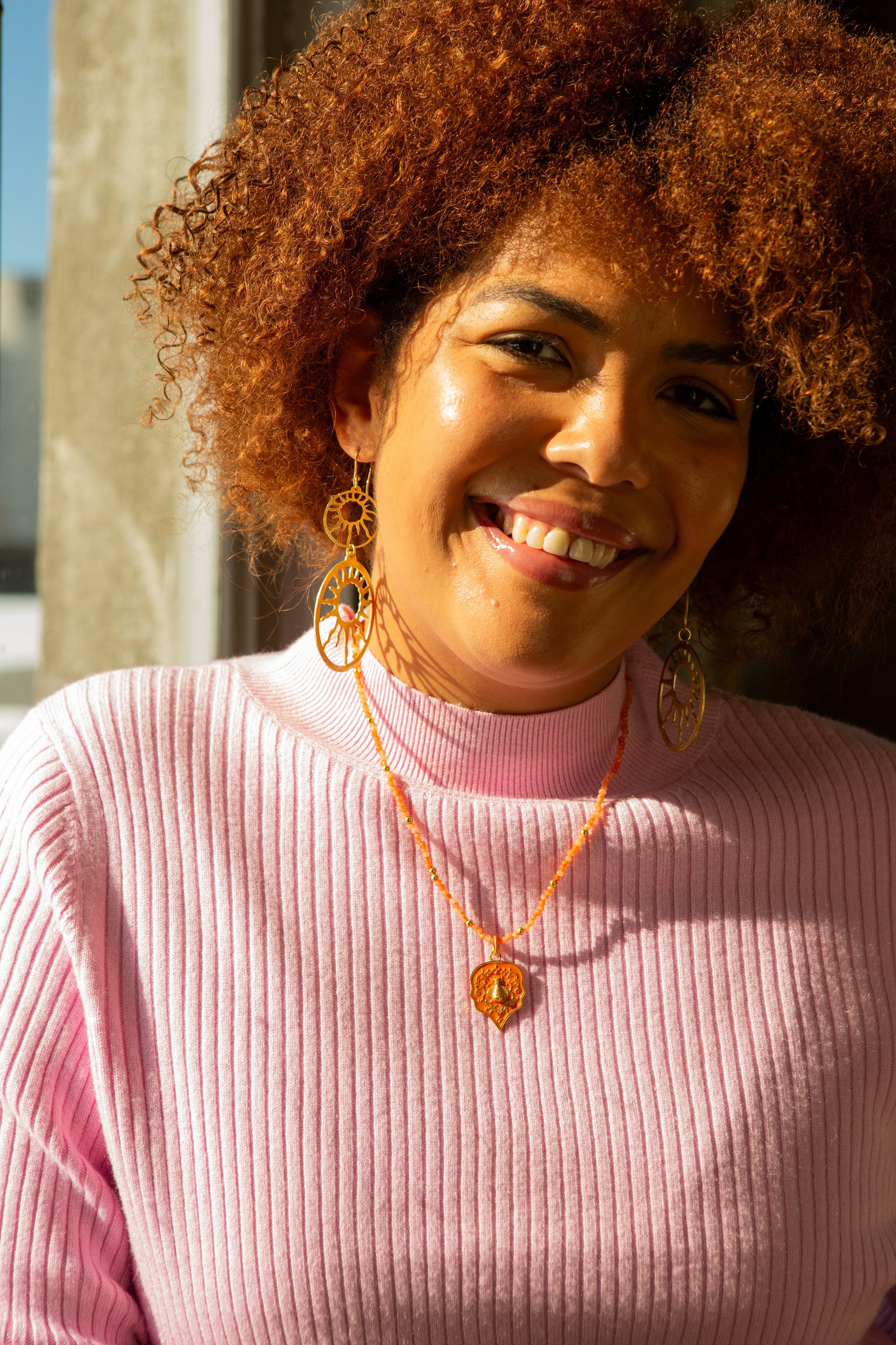 Close-up of bee pendant on stone bead necklace, nickel-free recycled brass, ethically made by women artisans