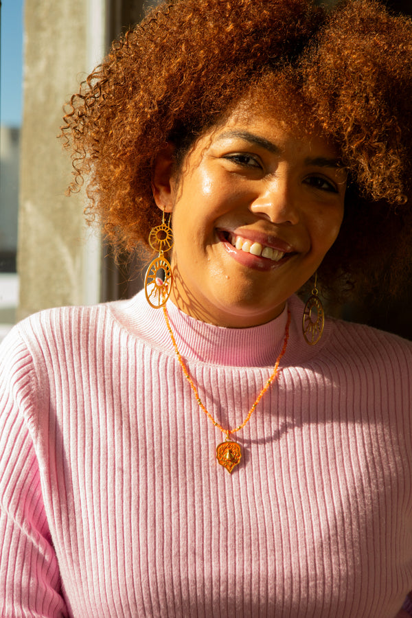 Close-up of bee pendant on stone bead necklace, nickel-free recycled brass, ethically made by women artisans