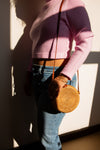 Boho rattan wicker bag styled as a crossbody, handcrafted by Fair Anita artisans