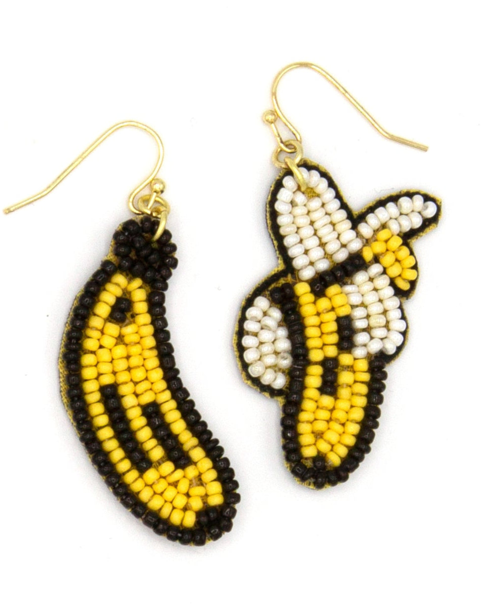 Fair trade handcrafted beaded banana earrings with yellow, black, and white glass beads on a flat surface