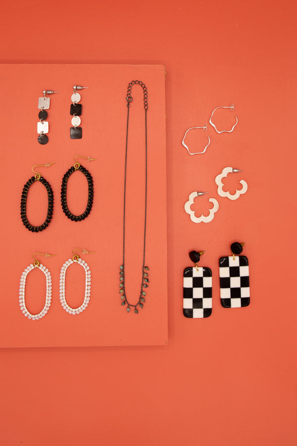 Model wearing Fair Anita 3-inch black and white checkered resin statement earrings