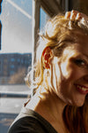 Model wearing Fair Anita Black Swan Winged Earrings styled as a dangle, fair trade handcrafted jewellery