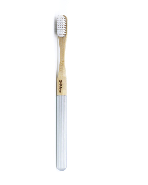 Bamboo toothbrush with white bristles on a white background