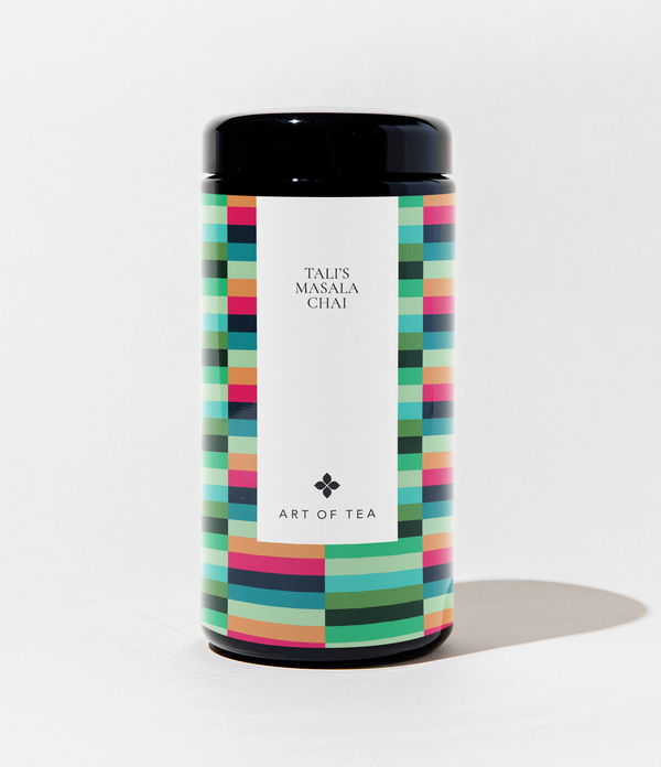 A cylindrical canister of Talis Masala Chai Art of Tea, featuring a colorful geometric pattern border and a clean white center label with black text, set against a plain white background.