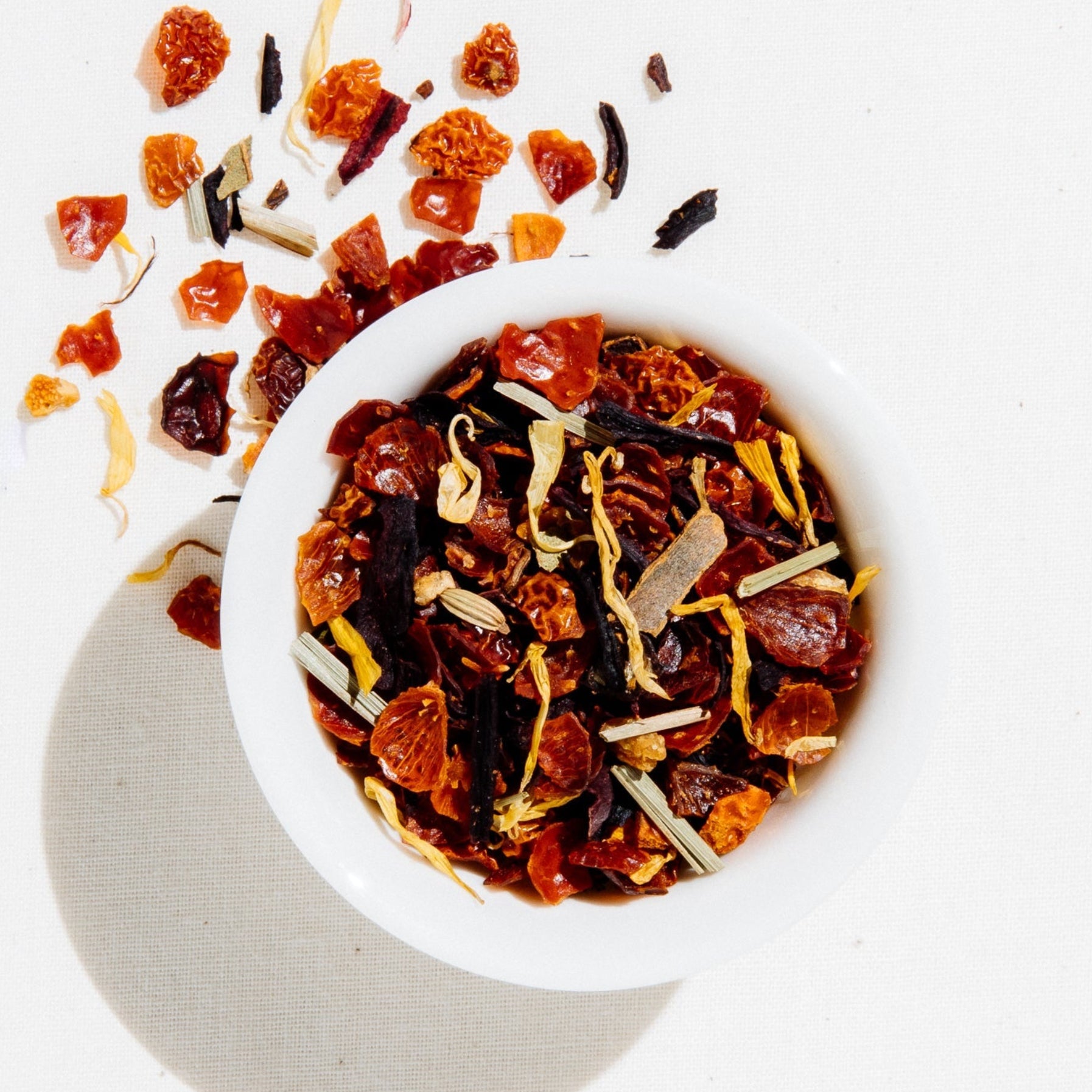 Apricot Escape caffeine-free herbal fruit tea by Art of Tea, shown loose leaf with a delicate blush-pink brew colour