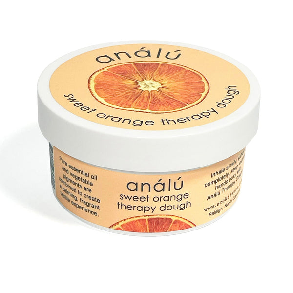 Child's hands squeezing Analu Sweet Orange therapy dough for sensory stress relief