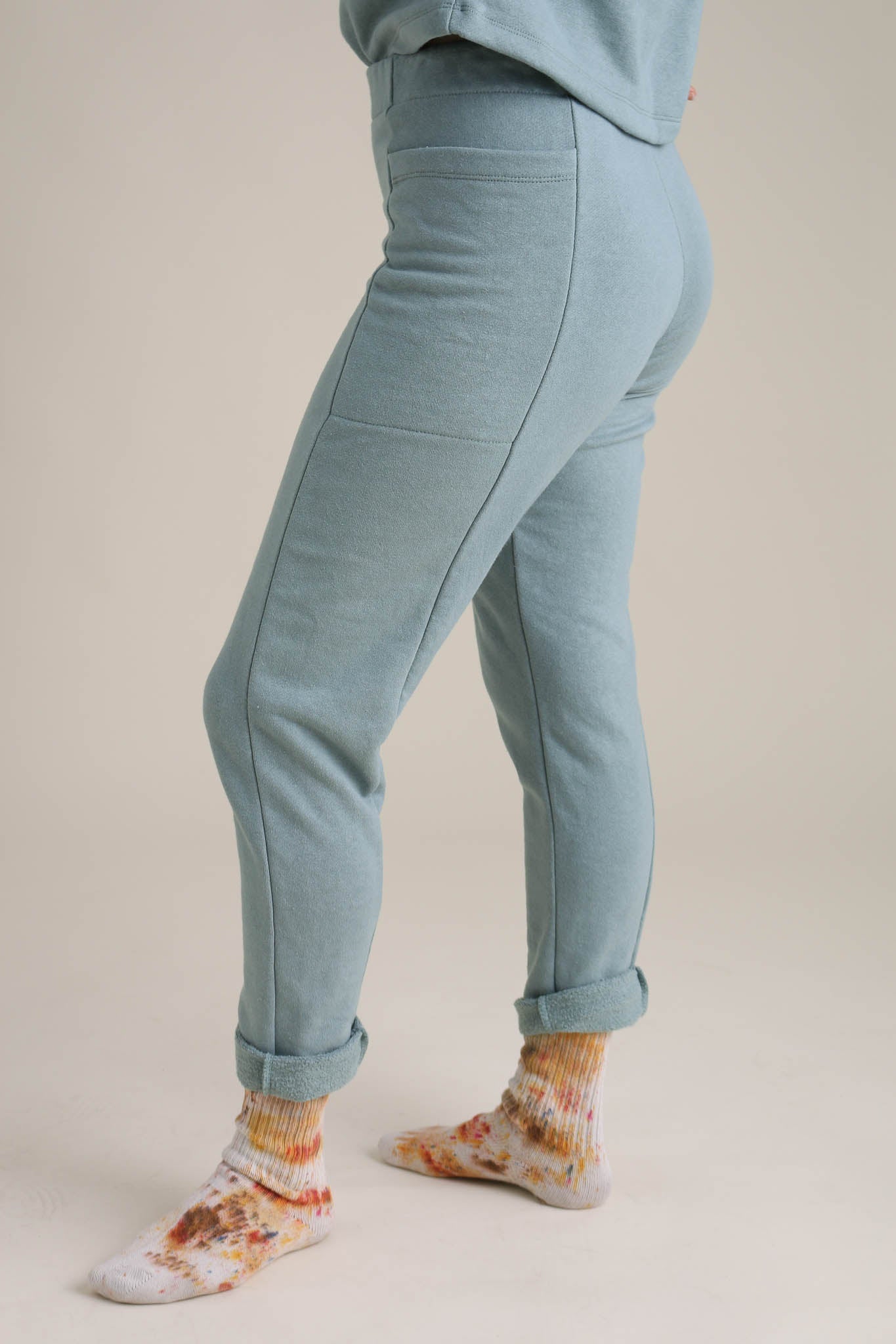 Light blue jogger pants worn by a person on a beige background