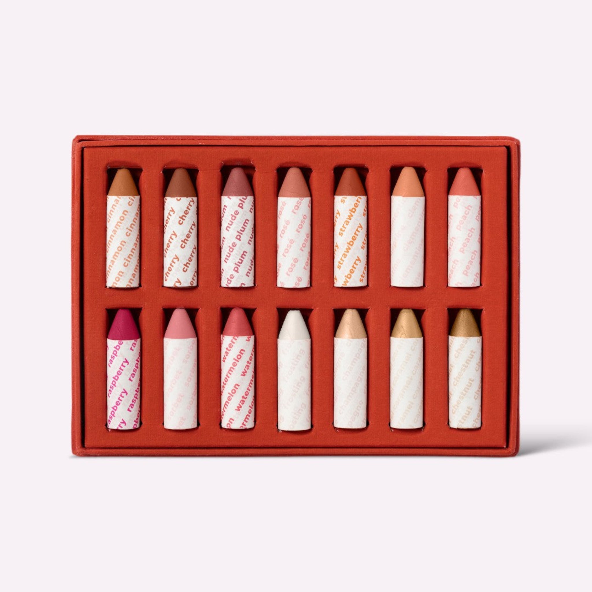A collection of Lip-to-Lid Balmies in various colors, packed in a recyclable orange box.