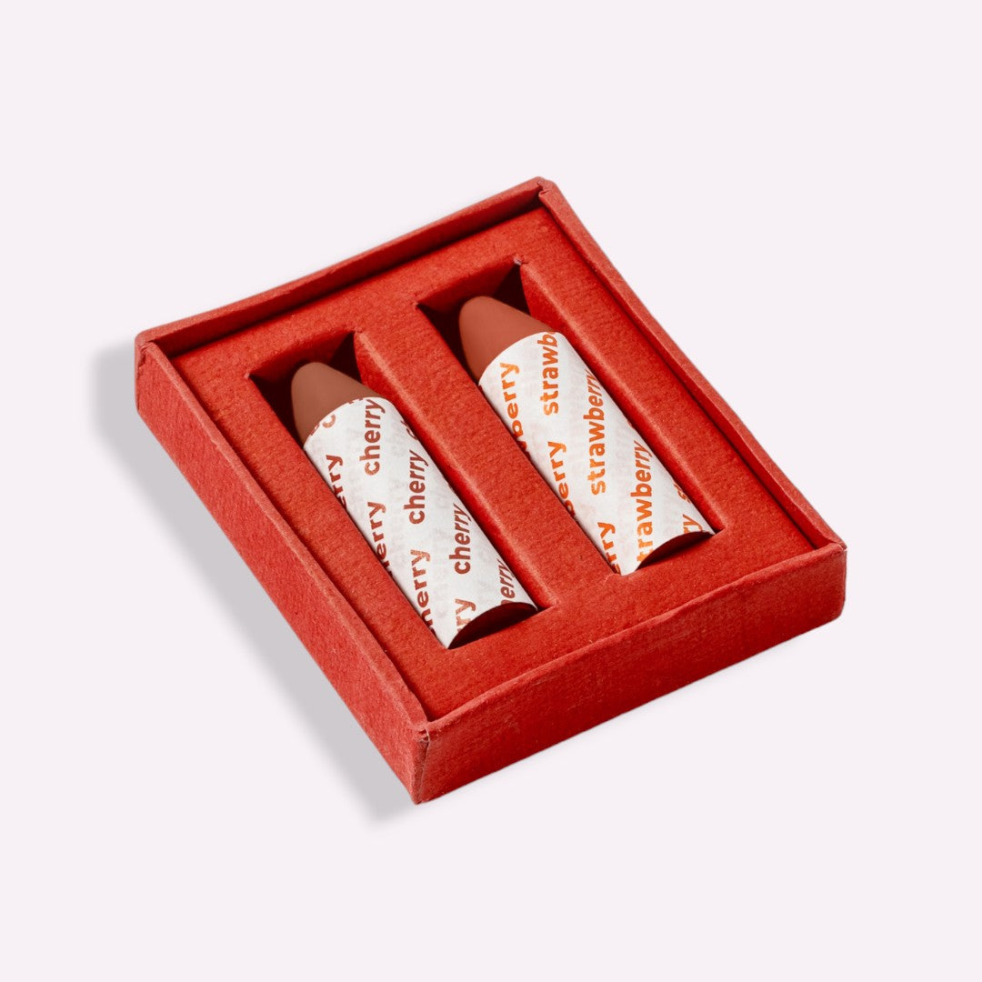 Two lip balm tubes in a red box on a light gray background