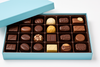 Assorted chocolates in a blue box on a white background
