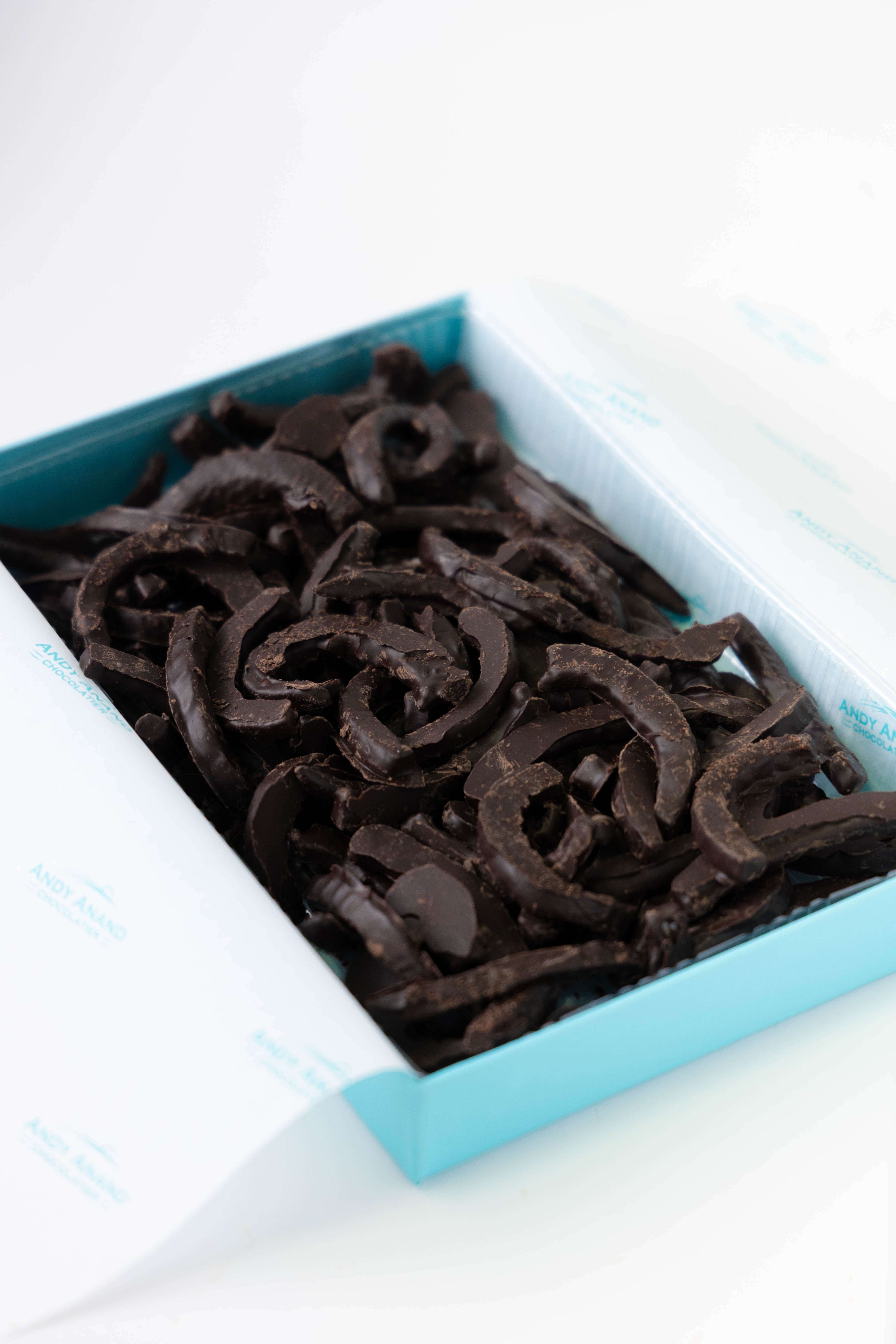 Blue square dish filled with dark chocolate licorice on a white background. Shop Dark Chocolate Cherry Peels. 1 lb of hand-dipped, vegan & gluten-free Italian gourmet treats. 60% dark chocolate. The perfect artisan luxury gift!