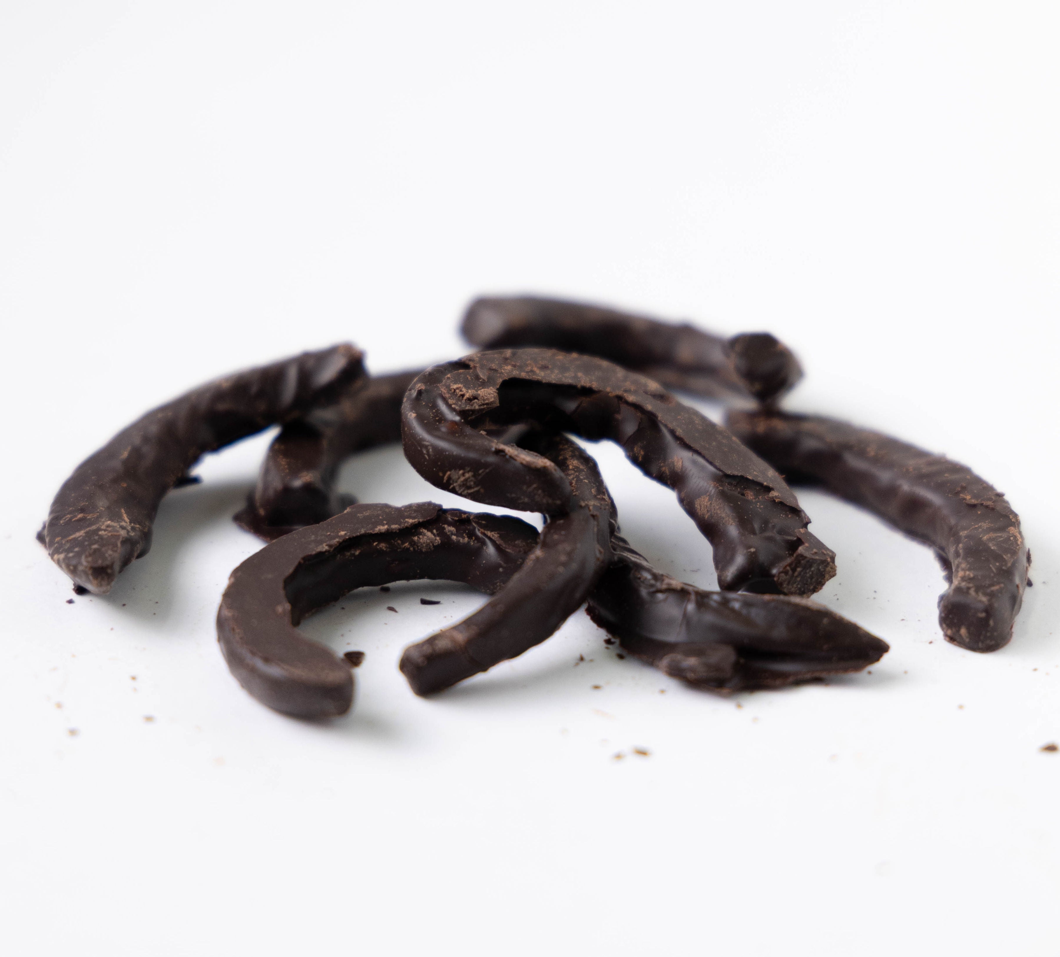 Dark chocolate pieces on a white background
