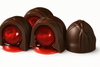 Chocolate truffles with red centers on a white background