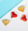 Heart-shaped candies on a white surface with a blue background