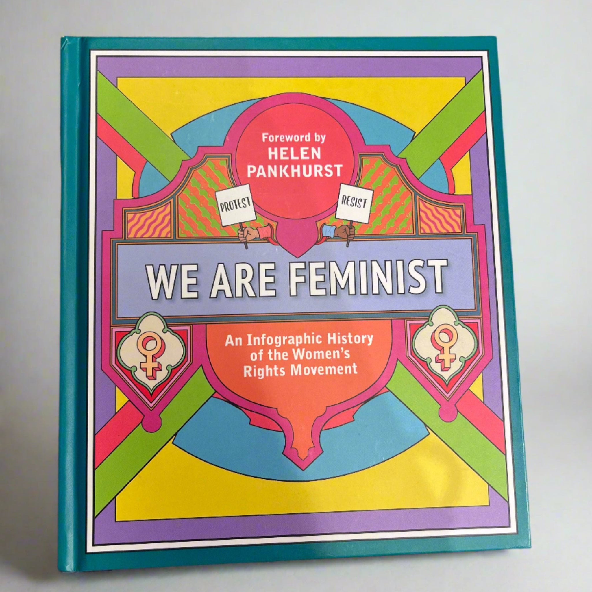 Colorful book cover titled 'We Are Feminist' by Helen Pankhurst on a textured surface.