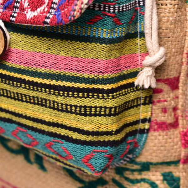 Colorful woven bag with geometric patterns and a natural fiber handle.