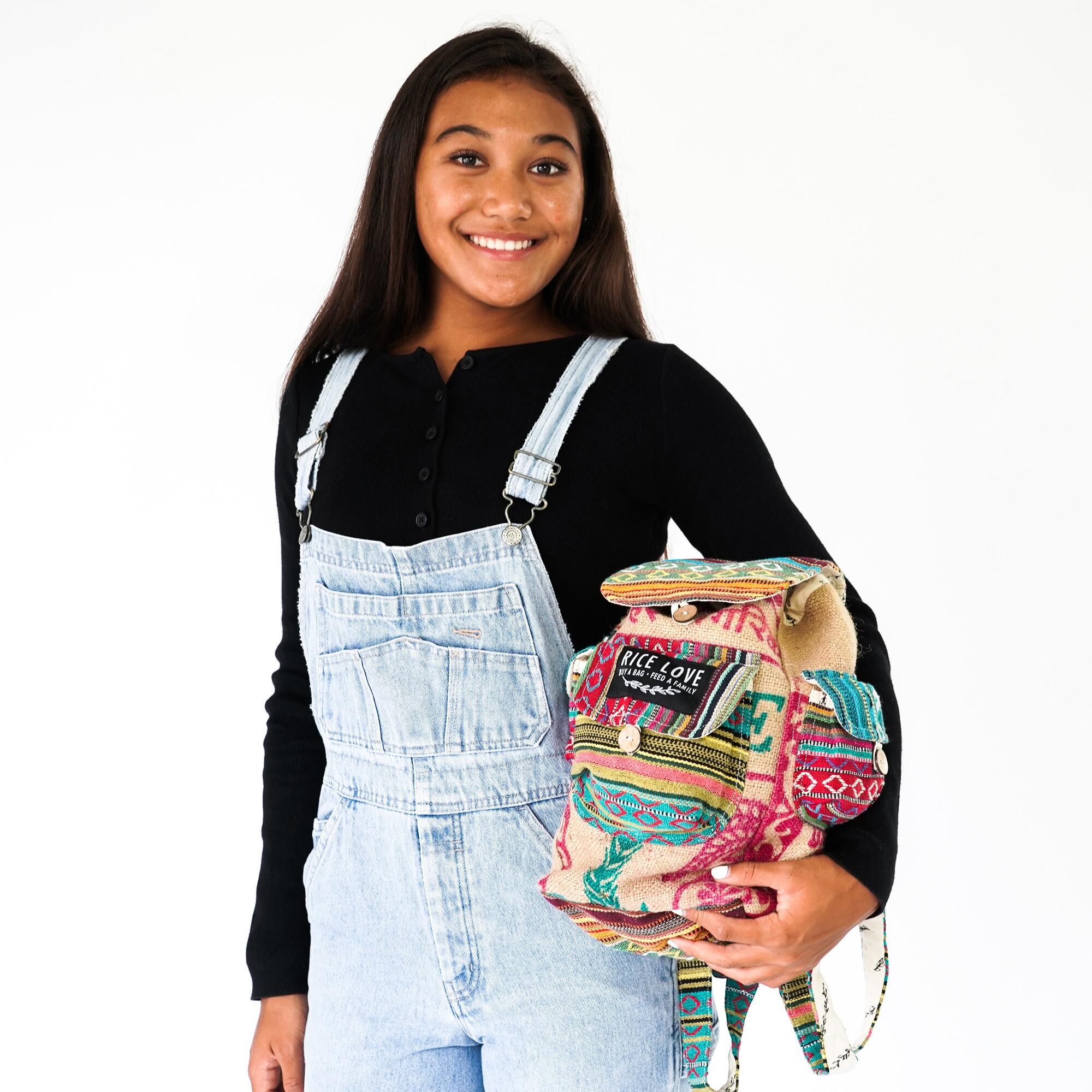 Person holding a colorful backpack with a white background