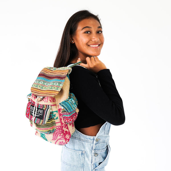 Person wearing a colorful patterned backpack on a white background
