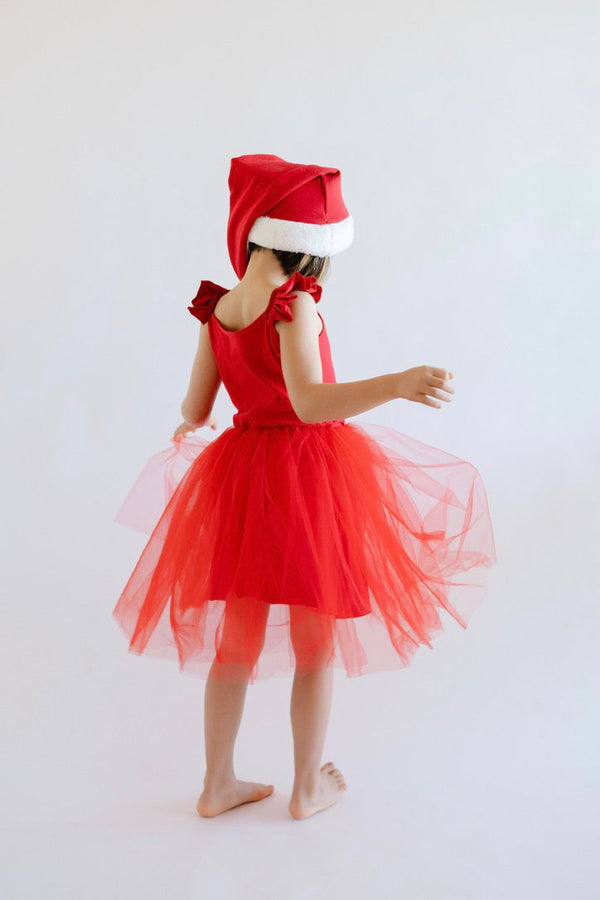 Child wearing a red dress with a Santa hat on a white background