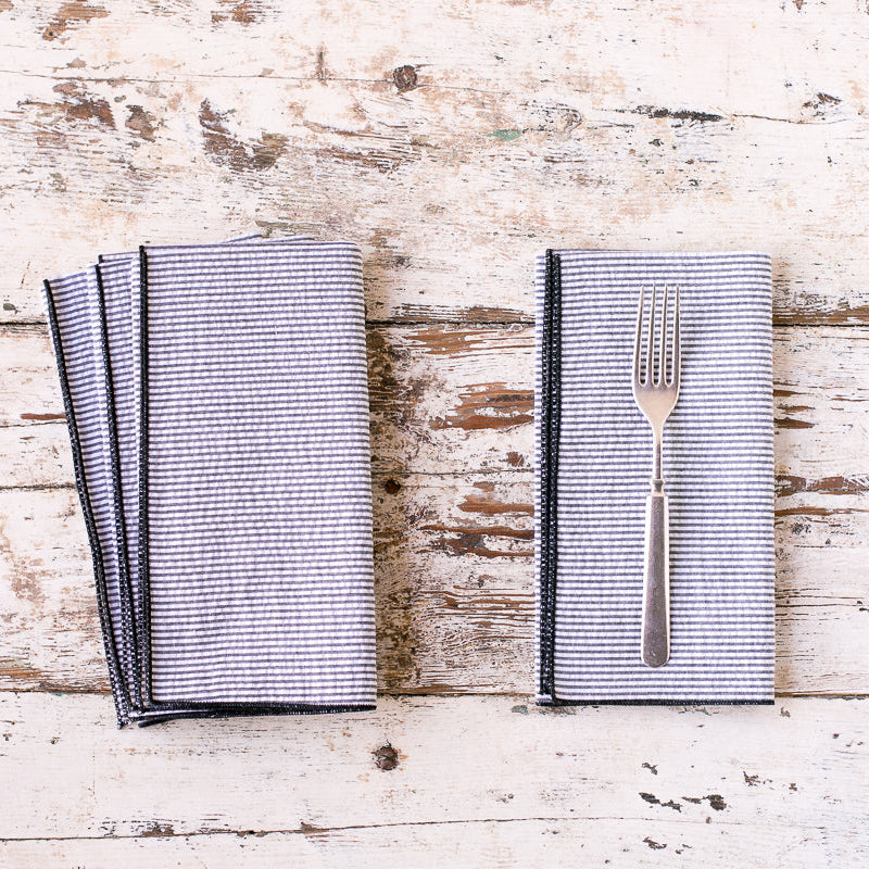 Set of gray napkins with a fork on a rustic wooden surface