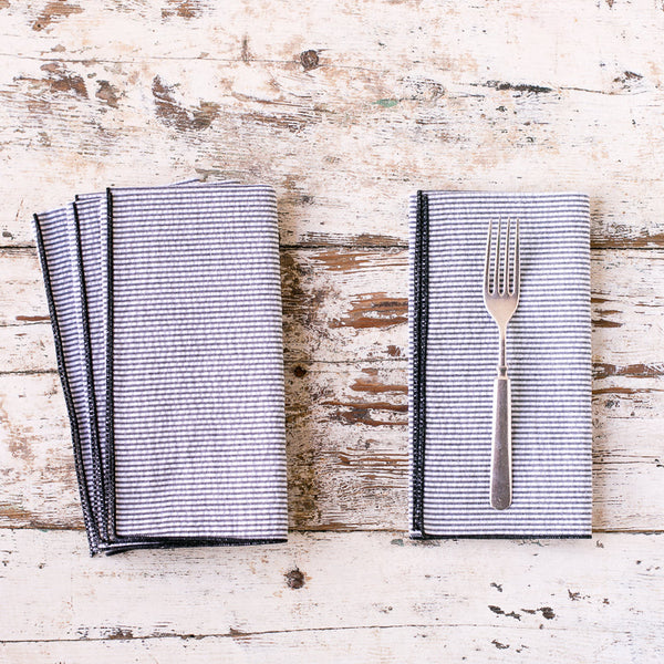 Set of gray napkins with a fork on a rustic wooden surface