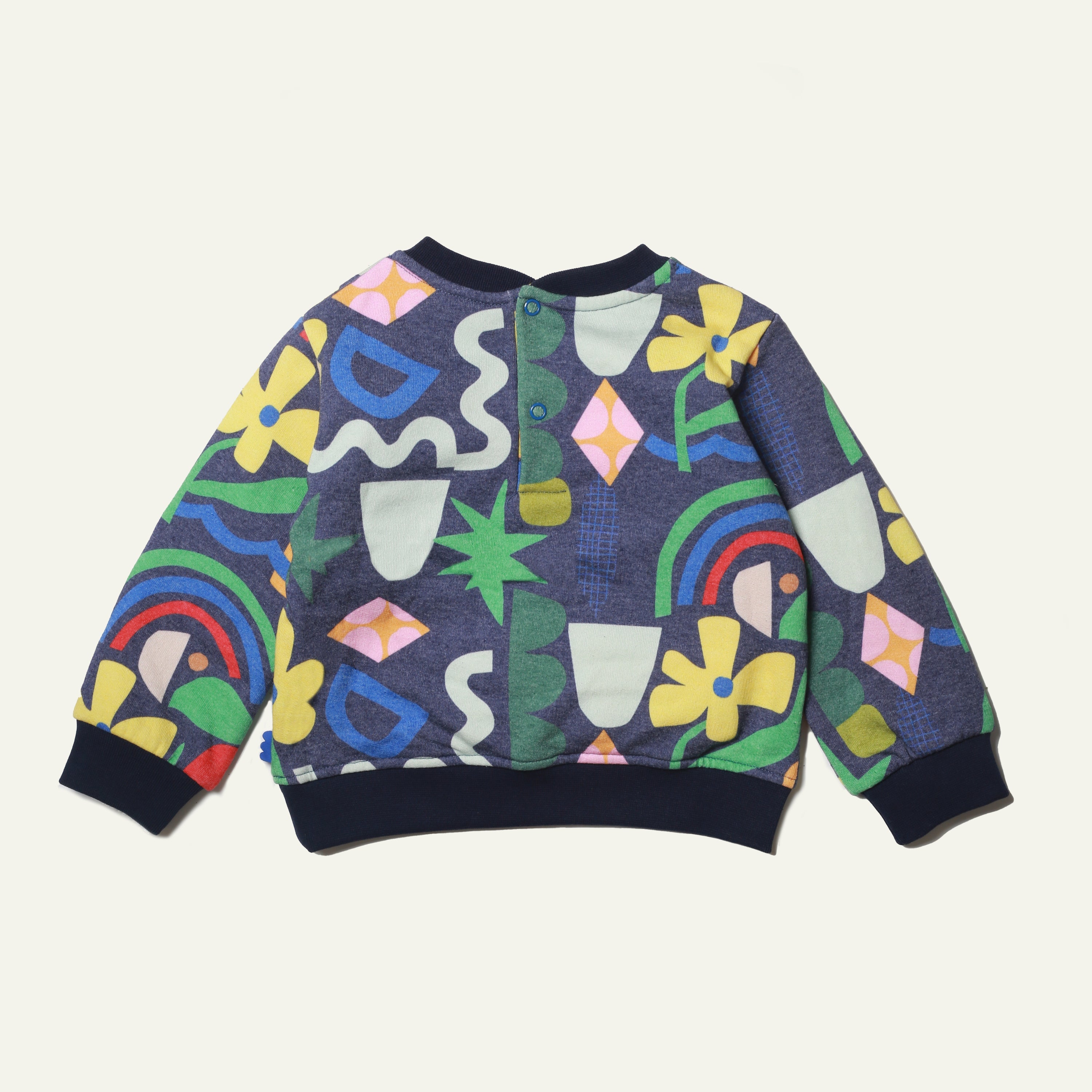 Close-up of Mon Coeur baby sweatshirt showing snap button back closure and ribbed hem detail